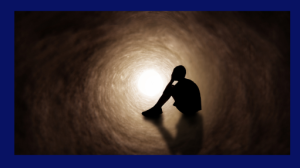 online therapy 14 This illustration shows the silhouette of a young man sitting in a tunnel with his head in this hands, showing intense sadness.