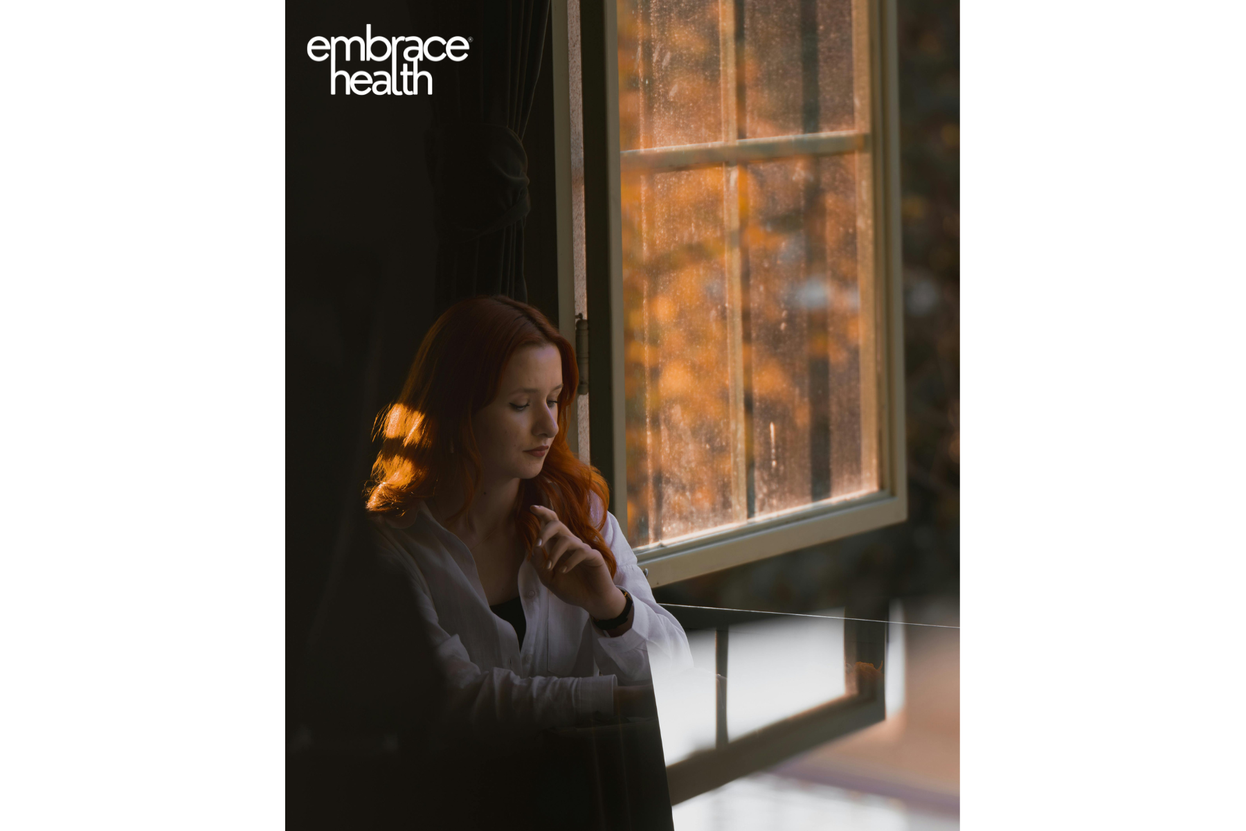 A woman worried about ADHD and anxiety sits pensively by a window