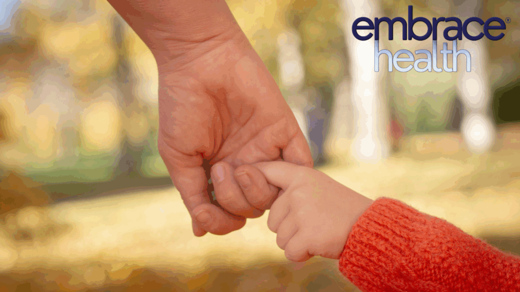 An adult hand gently holds a child's hand, guiding them towards a better future as a metaphor for healing the inner child.